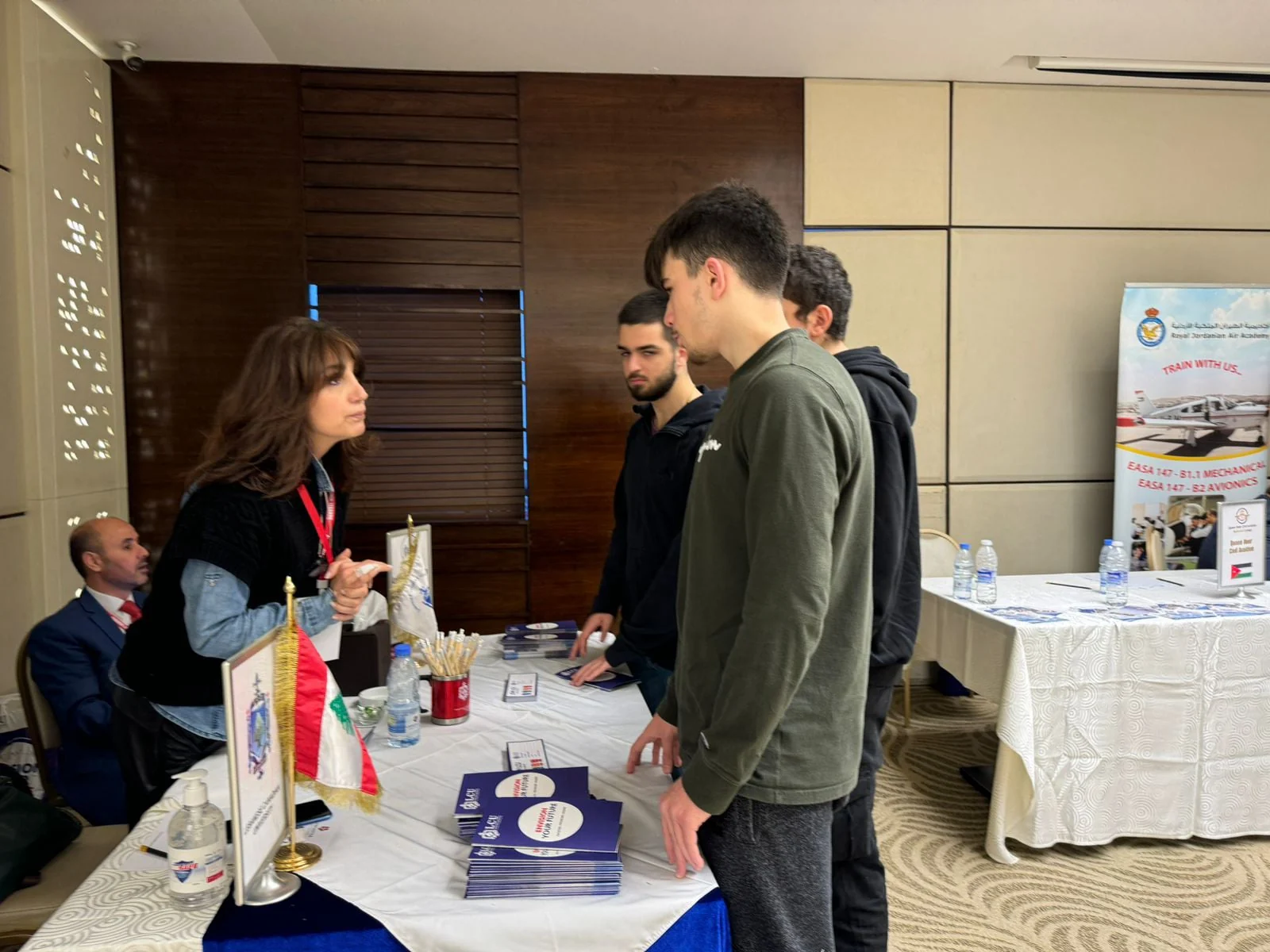 طلاب يتحدثون إلى ممثل جامعة عند جناحها التعريفي